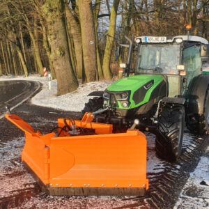 großer Traktor im Winterdienst mit Schiebeschild